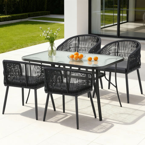 Outdoor dining set with black chairs and a glass table on a patio.
