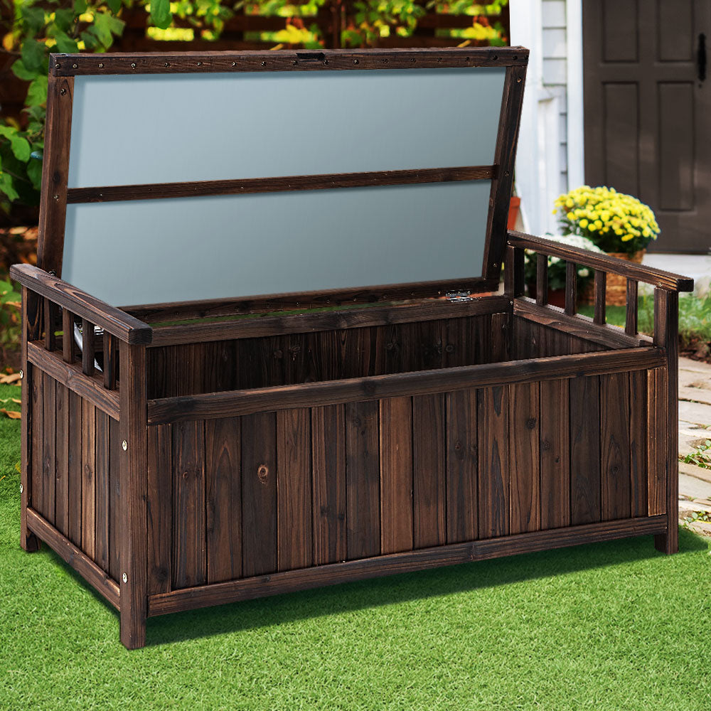 Wooden storage bench with a dark brown finish on a grassy area.