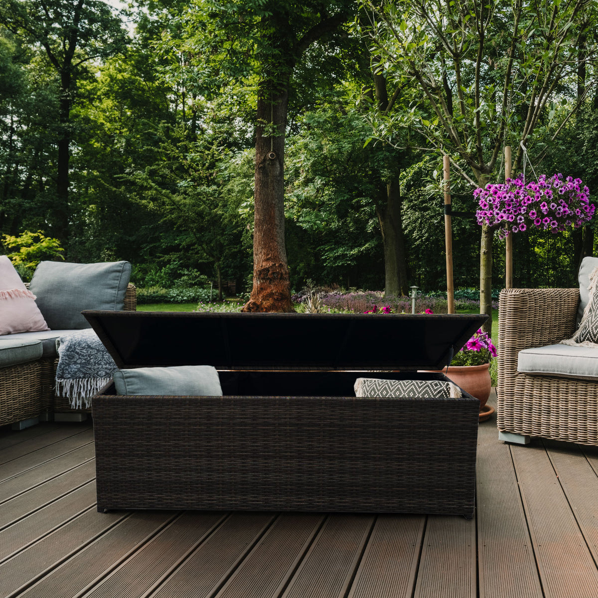 Outdoor patio with wicker furniture, fire pit, and greenery